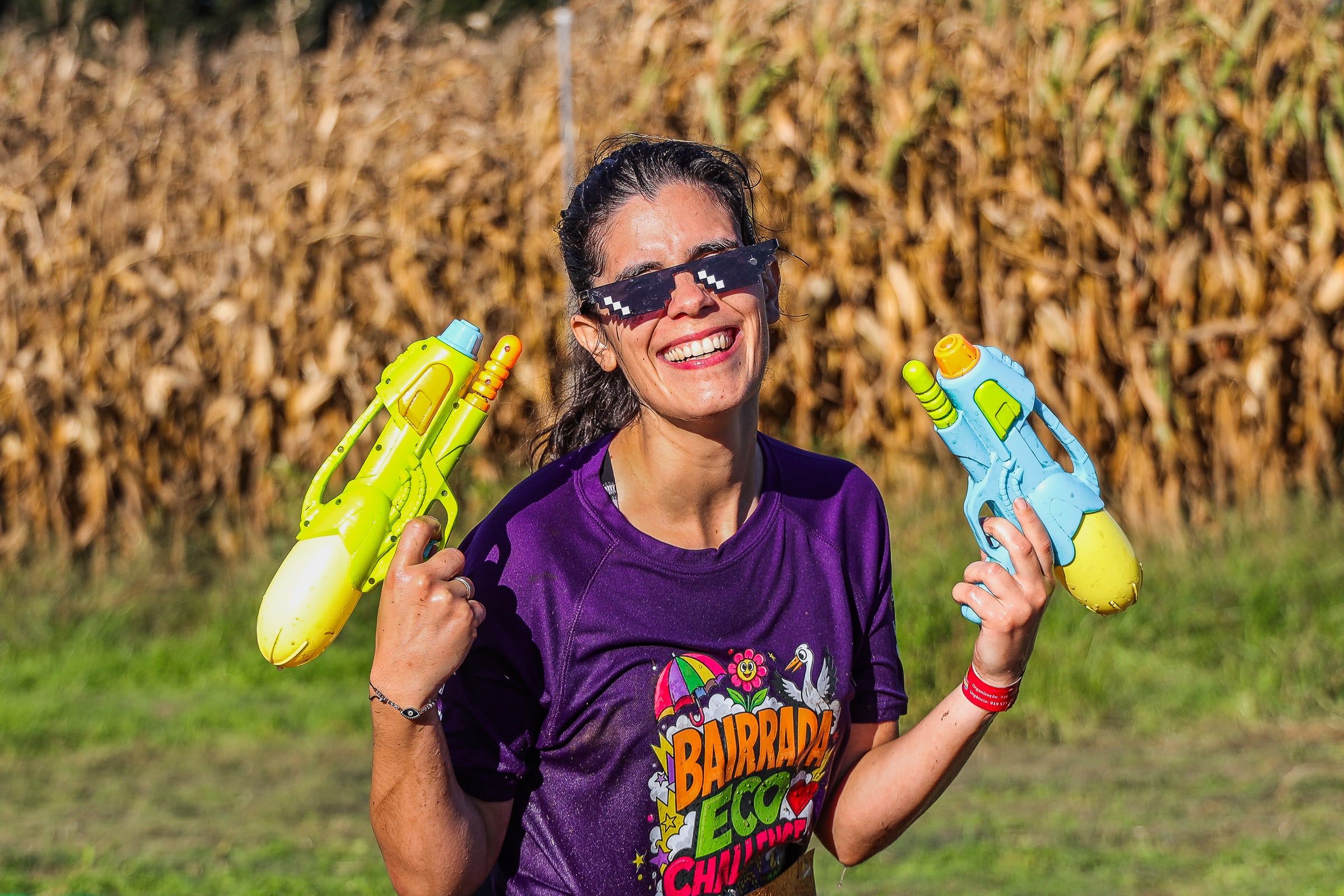 A smiling participant holding two water pistols.